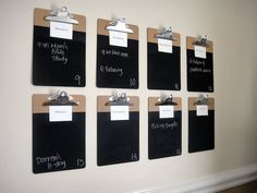 there are many black and white clipboards on the wall with magnets attached to them