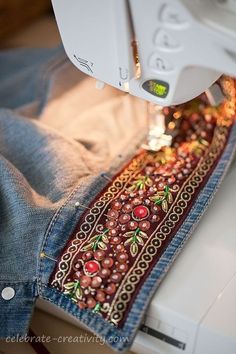 someone is using a sewing machine to sew something on the jeans they are wearing