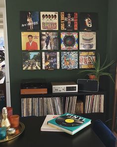 a record player sitting on top of a table next to a shelf filled with records