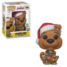 a pop vinyl dog wearing a santa hat and christmas lights on its chest, next to a box