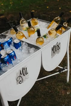 a cooler filled with lots of bottles of wine and glasses on top of ice cubes