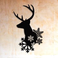 a metal deer with snowflakes on it's antlers is mounted to the side of a wall