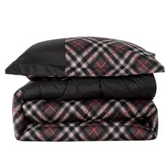 three pillows stacked on top of each other with black and red plaid sheets in the background