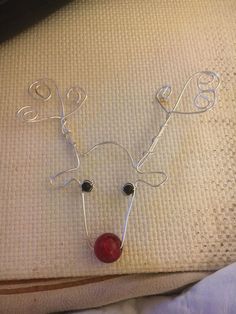 a wire reindeer head with a red glass bead on it's nose and eyes