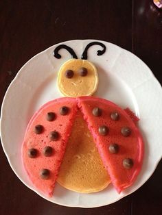 a white plate topped with a cake shaped like a lady bug