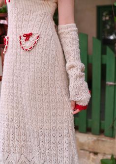 a woman in a white dress and red gloves is holding her hand out to the side