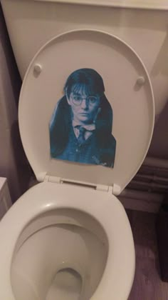 a toilet with the lid up and an image of harry potter on it