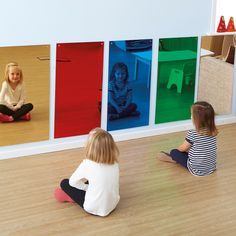 two children sitting on the floor in front of colorful pictures