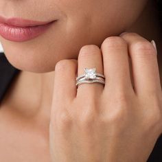 a woman wearing a wedding ring with a princess cut diamond on it's band