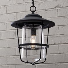 an outdoor light hanging from a brick wall