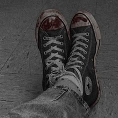 black and white photograph of someone's shoes with blood on them