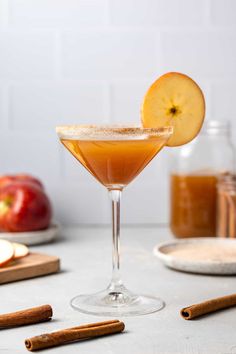 an apple cider sitting on top of a table next to cinnamon sticks