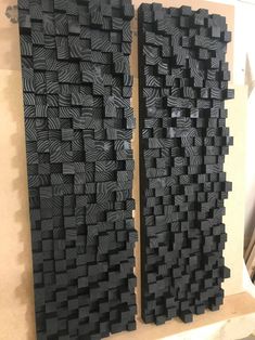 two pieces of art made out of black wood