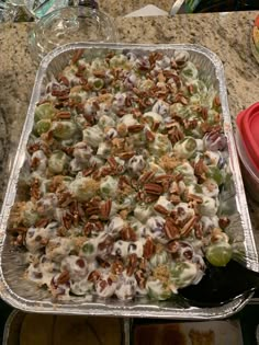 a tray filled with grapes and pecans on top of a counter next to other dishes