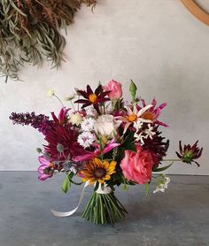 a vase filled with lots of different colored flowers