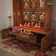 a wooden cabinet sitting on top of a rug in front of a wall with pictures