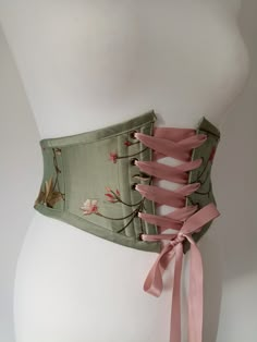 Beautiful handmade sage / olive green floral silk corset belt with autumnal leaves embroidered, ideal for renaissance fair costume accessory.  Free worldwide shipping and sent with a tracking number. Sizes available are to fit: XS:  Waist: 25" - 27" S: Waist: 28" - 29" M: Waist: 29.5" - 31.5" L: Waist: 32" - 33.5" XL: Waist: 34" - 35.5" Crafted from gorgeous sage /olive green silk with pretty flowers and leaves embroidered all over. Dusky pink satin ribbon for front lacing. Bias binding made fro Waist Belts For Dresses, Floral Underbust Corset, Brown Corset Belt, Moss Corset, Green Underbust Corset, Corset Designs Ideas, Fabric Belts For Women, Sage Green Accessories, Fairy Belt