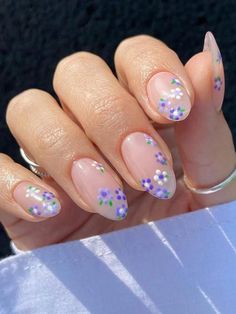 a woman's hand with some pink and purple nail polishes on her nails