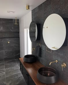 a bathroom with two sinks and mirrors on the wall