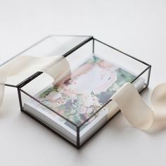 a glass box that has some white ribbons in it