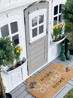 a door mat that says home sweet home next to some potted plants and flowers