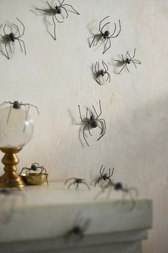 many black and white spider webs are on the wall next to a candle holder