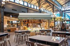 the inside of a restaurant with tables, chairs and food on display in front of them