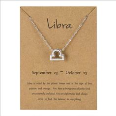 a silver necklace with the words libra written on it and an open lock pendant