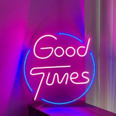 a neon sign with the words good times on it's side next to a window