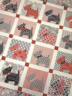 a quilt made to look like dogs with polka dots on them and red, white, and black squares