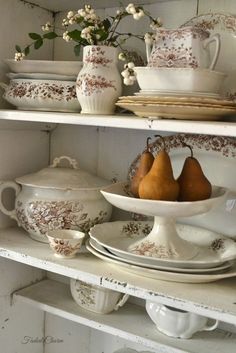 an old china cabinet with pears, plates and bowls on it's shelves