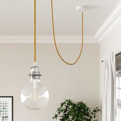 a living room with a couch, coffee table and hanging light fixture in the corner