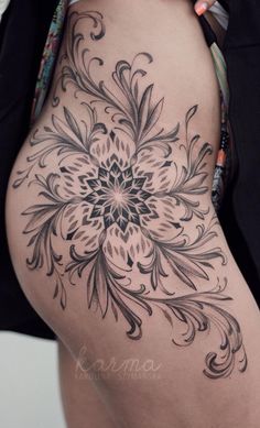 a woman's stomach with an intricate flower tattoo on the side and bottom part