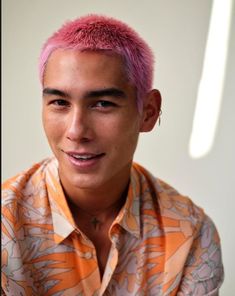 a young man with pink hair wearing an orange shirt