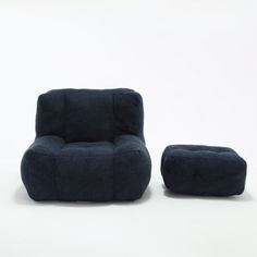 a blue chair and ottoman sitting next to each other on a white surface with one foot in the air