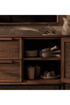 a wooden cabinet with plates and bowls on it