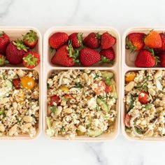 four trays filled with different types of food on top of a marble countertop