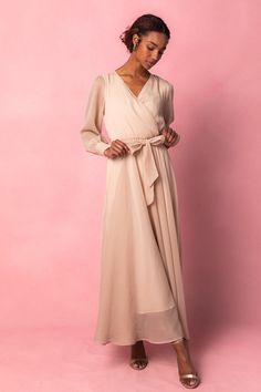 Andie Dress in Champagne – Ivy City Co Chic Belted Maxi Dress With Surplice Neckline, Elegant Flowy Beige Maxi Dress, Cream Maxi Dress With Flowy Skirt, Chic Maxi Dress With Surplice Neckline For Work, Cream Maxi Length Dress With Flowy Skirt, Elegant Beige Wrap Dress With Surplice Neckline, Flowy Maxi Length Faux Wrap Dress, Chic Flowy Wrap Maxi Dress, Chic Bridesmaid Midi Dress With Surplice Neckline