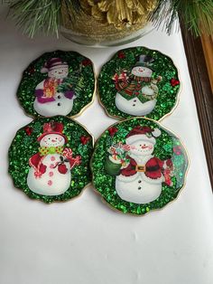 four decorated christmas plates sitting on top of a table