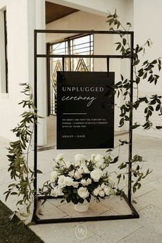 an unplugged ceremony sign with white flowers on display in front of it