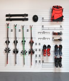 there are many pairs of skis and snowboards on the wall next to each other