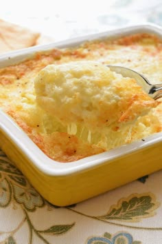 a spoon full of food in a yellow casserole dish