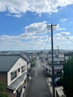 an empty street with houses and power lines in the distance