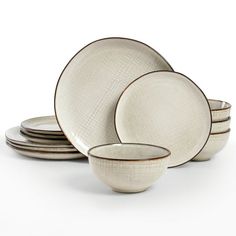 a set of four white dishes with black rims