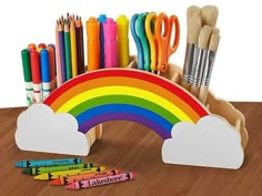 a wooden desk with markers, crayons, and pencils in the shape of a rainbow