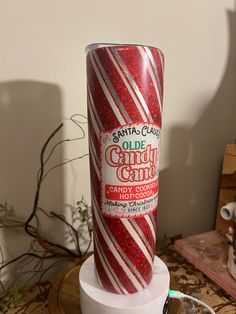 a candy cane candle is sitting on a stand