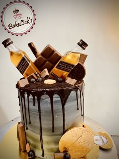 a cake with chocolate icing and liquor bottles on top