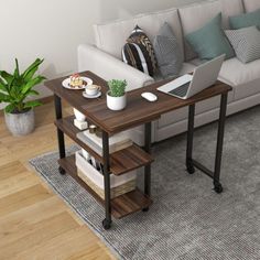 a laptop computer sitting on top of a wooden table next to a white couch in a living room