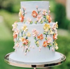 a three tiered cake decorated with colorful flowers