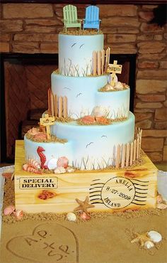 a three tiered cake decorated with beach scenes